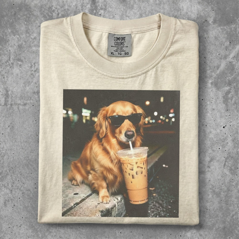 Golden retriever in sunglasses sips an iced coffee on a curb.