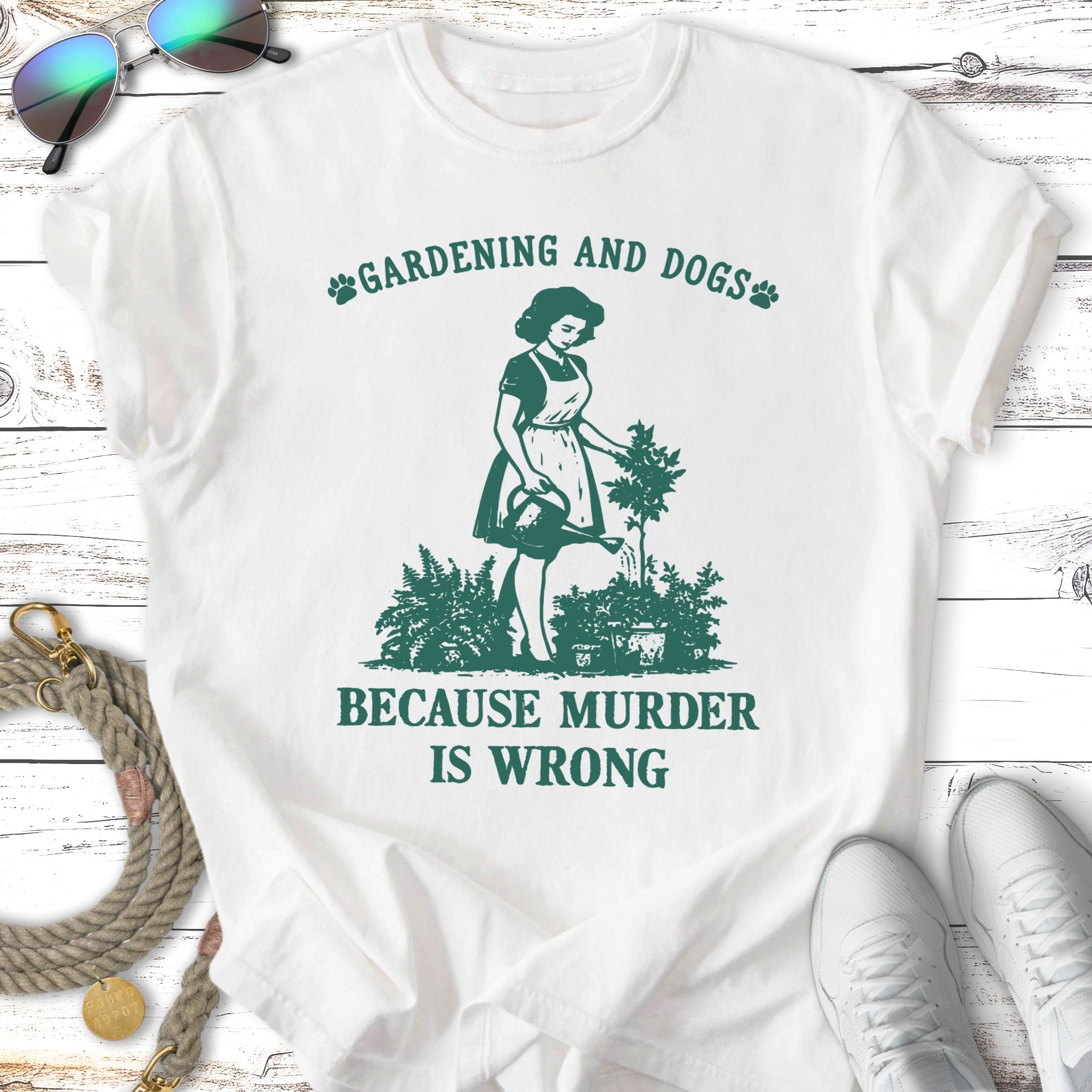 White t-shirt with "Gardening and Dogs Because Murder Is Wrong" text and gardening graphic.