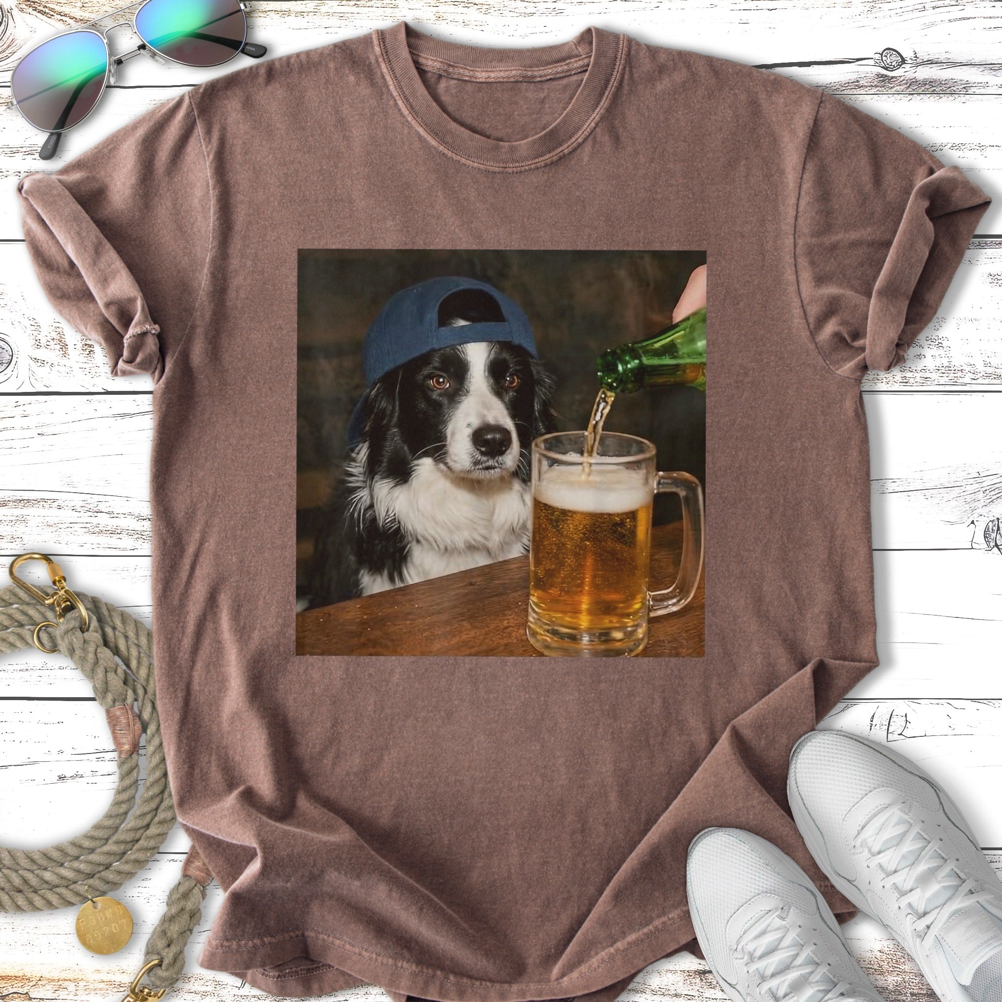 Border collie wearing a baseball cap pours a beer into a mug.