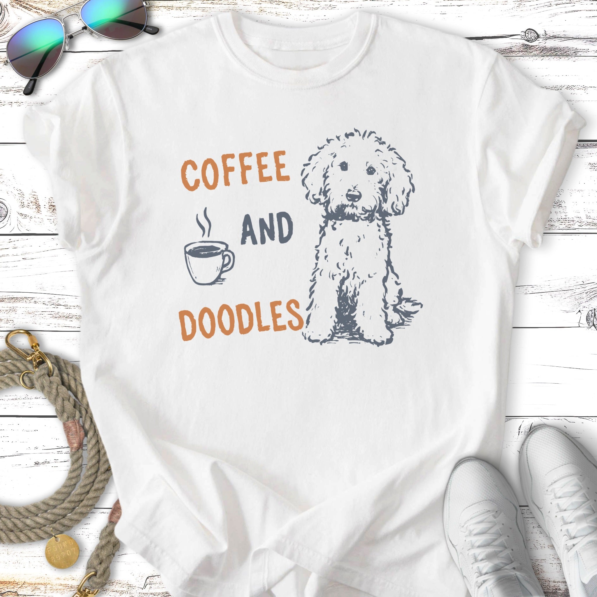 White t-shirt with illustration of a dog and "Coffee and Doodles" text.