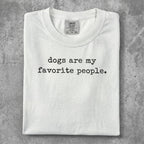 White t-shirt with "dogs are my favorite people" printed in black text.
