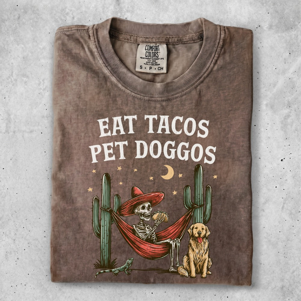 Skeleton in hammock eating tacos with dog, cacti, and moon.