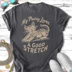 Cat stretching with text "My Pussy Loves A Good Stretch" on vintage t-shirt.