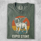 Pug with wings on skateboard, "Cupid Stunt" text, retro sunset background.