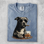 Dog wearing sunglasses and smoking cigar with whiskey.