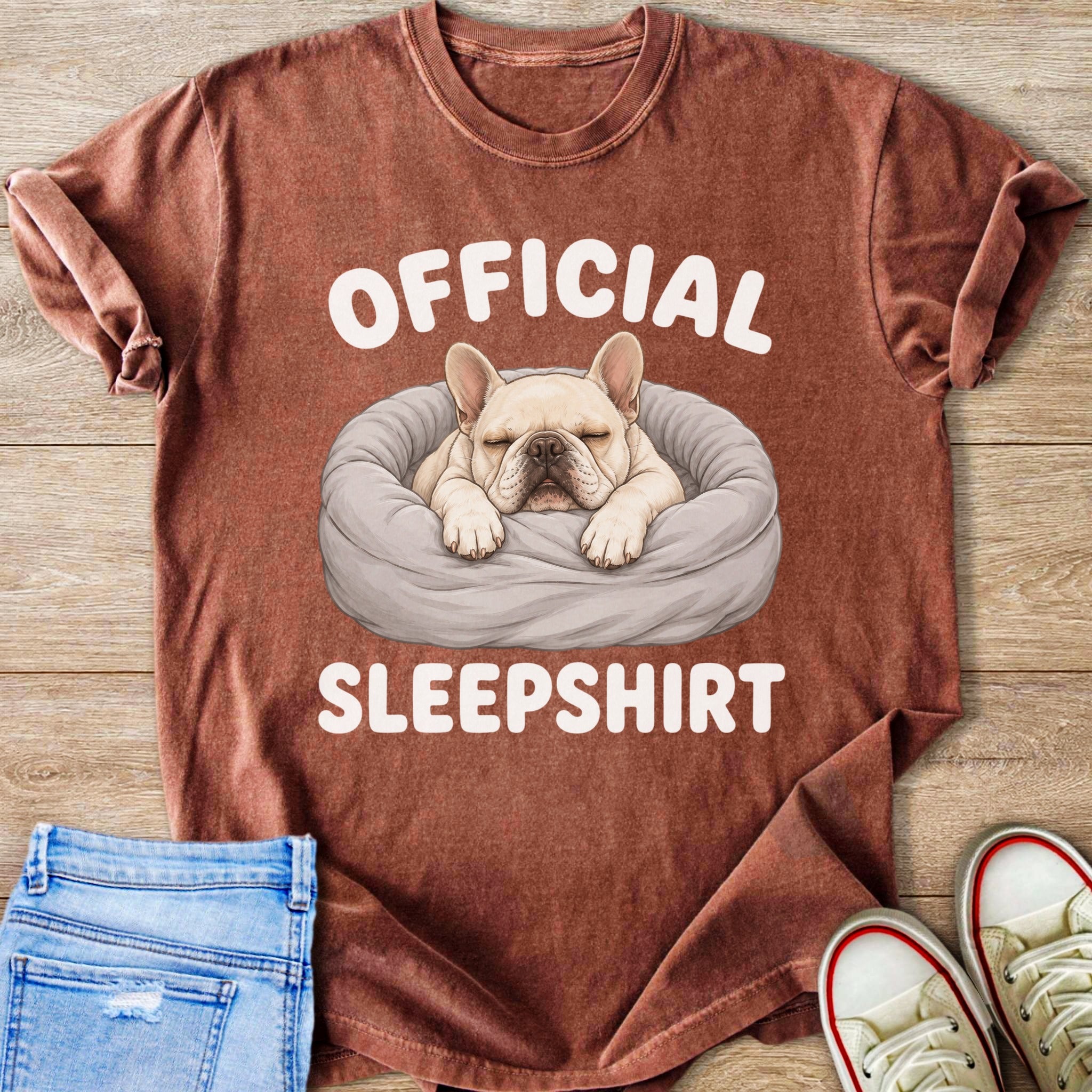 French Bulldog in bed with text "OFFICIAL SLEEPSHIRT" on a rust colored shirt.