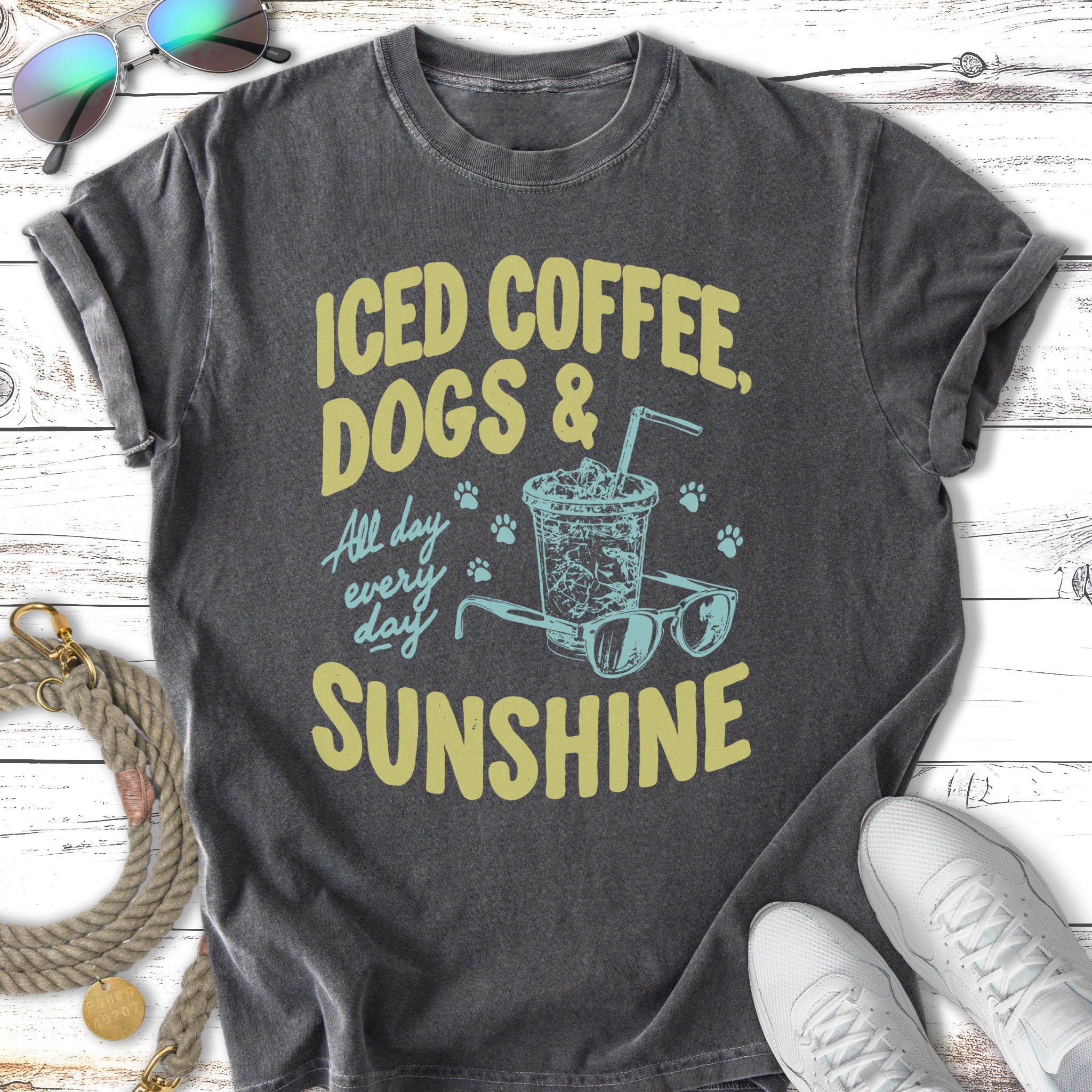 Iced coffee, dogs, and sunshine text on a t-shirt with sunglasses and paw prints.