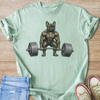 Buff French bulldog lifting heavy barbell weight on mint green t-shirt.