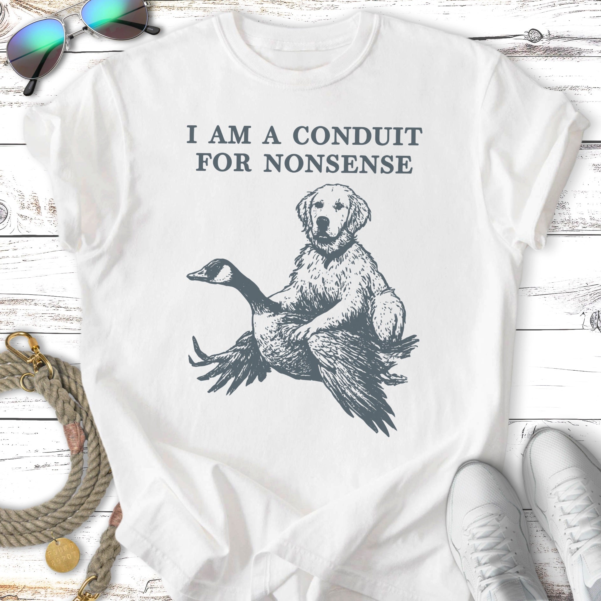 White t-shirt with a dog riding a goose, text reads "I AM A CONDUIT FOR NONSENSE".