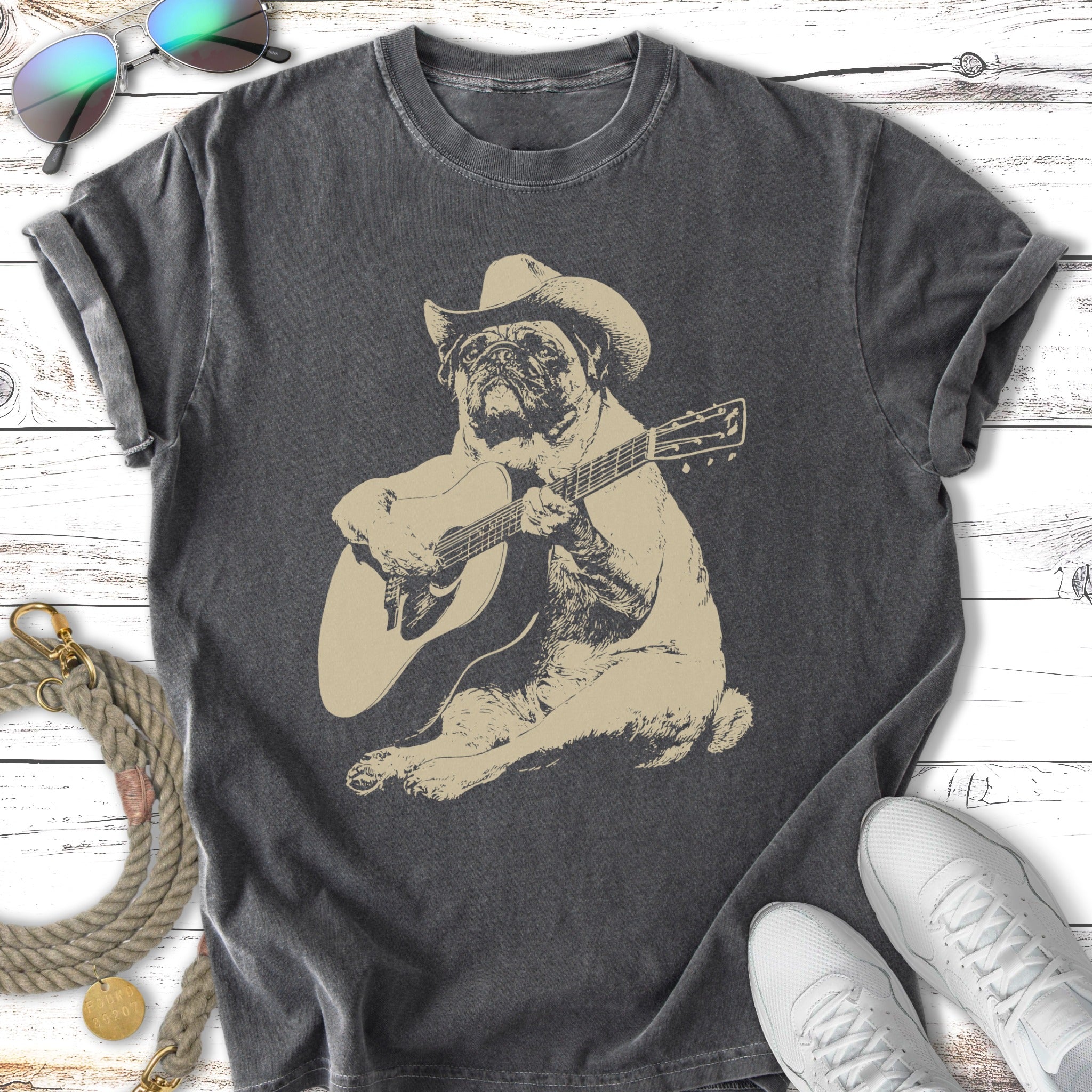 Pug wearing a cowboy hat plays an acoustic guitar.