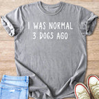 Gray t-shirt with white text reading "I WAS NORMAL 3 DOGS AGO"