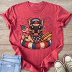 French bulldog in swim ring with American flag and hot dog, "Merica" hat.
