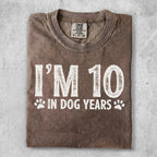 Brown t-shirt with "I'M 10 IN DOG YEARS" text and paw prints.
