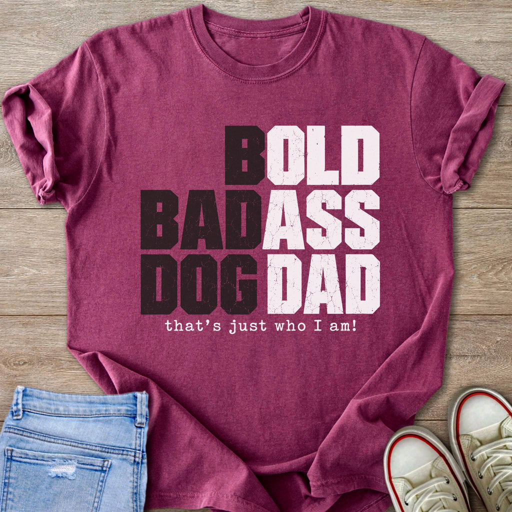 Maroon t-shirt with bold text reading "BOLD BADASS DOG DAD that's just who I am!".