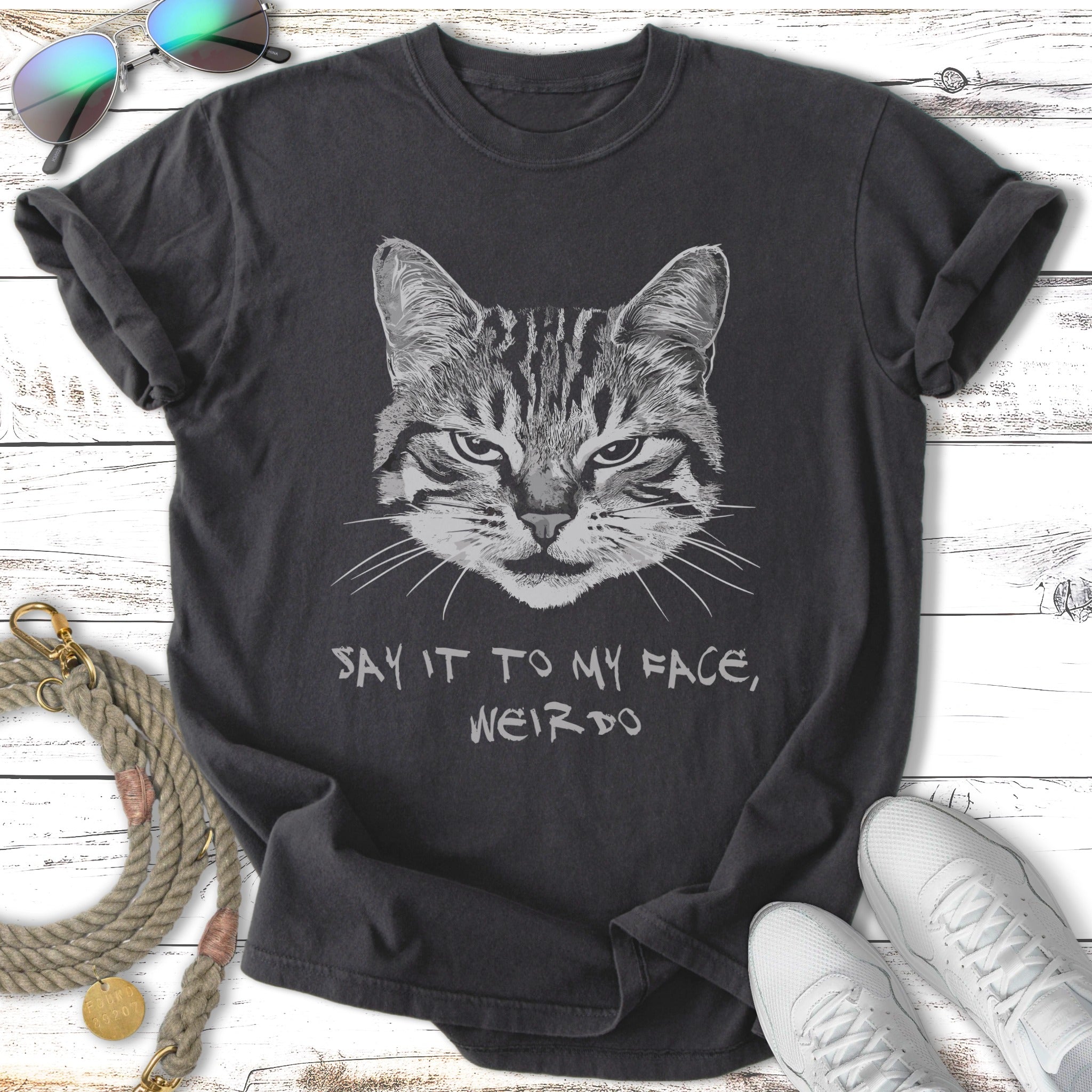 Gray t-shirt with a tabby cat's face and "Say it to my face, weirdo" text.