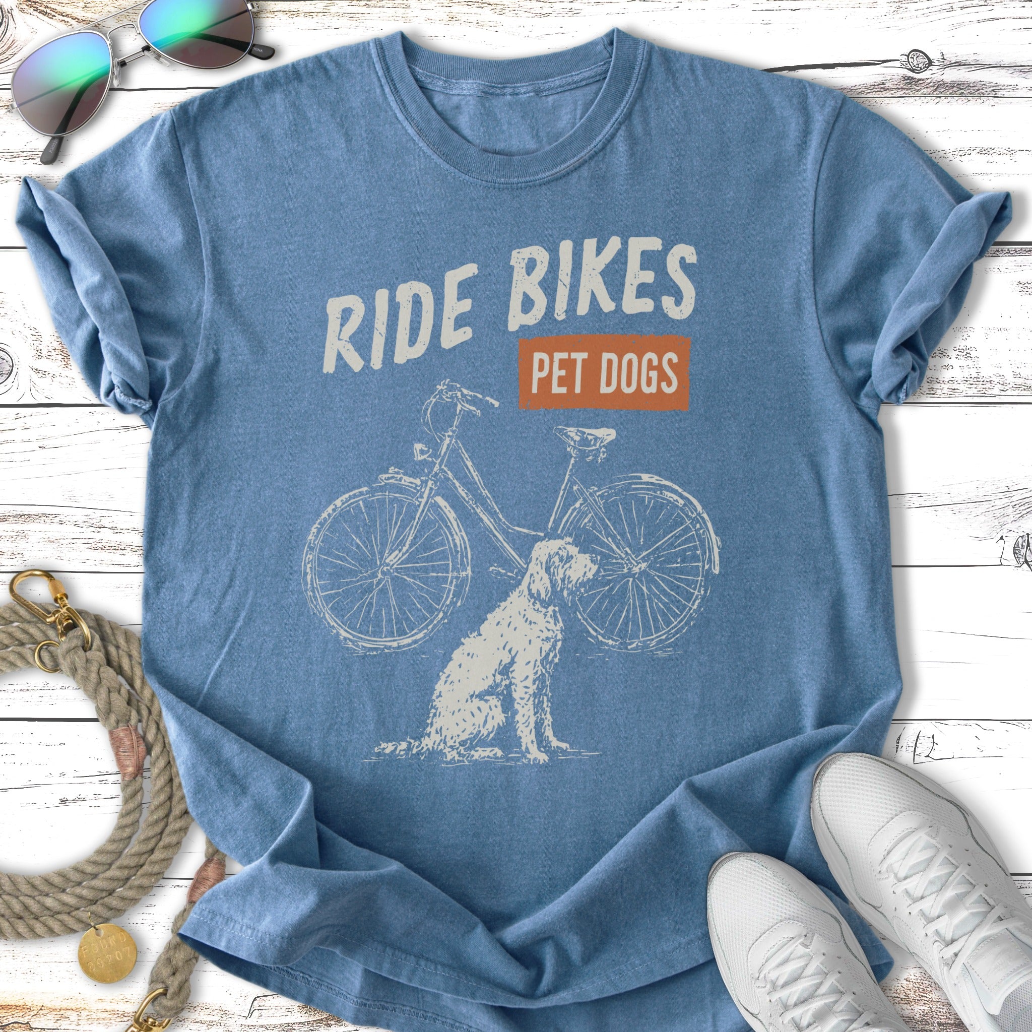 Blue t-shirt with "Ride Bikes Pet Dogs" text and bicycle and dog illustration.