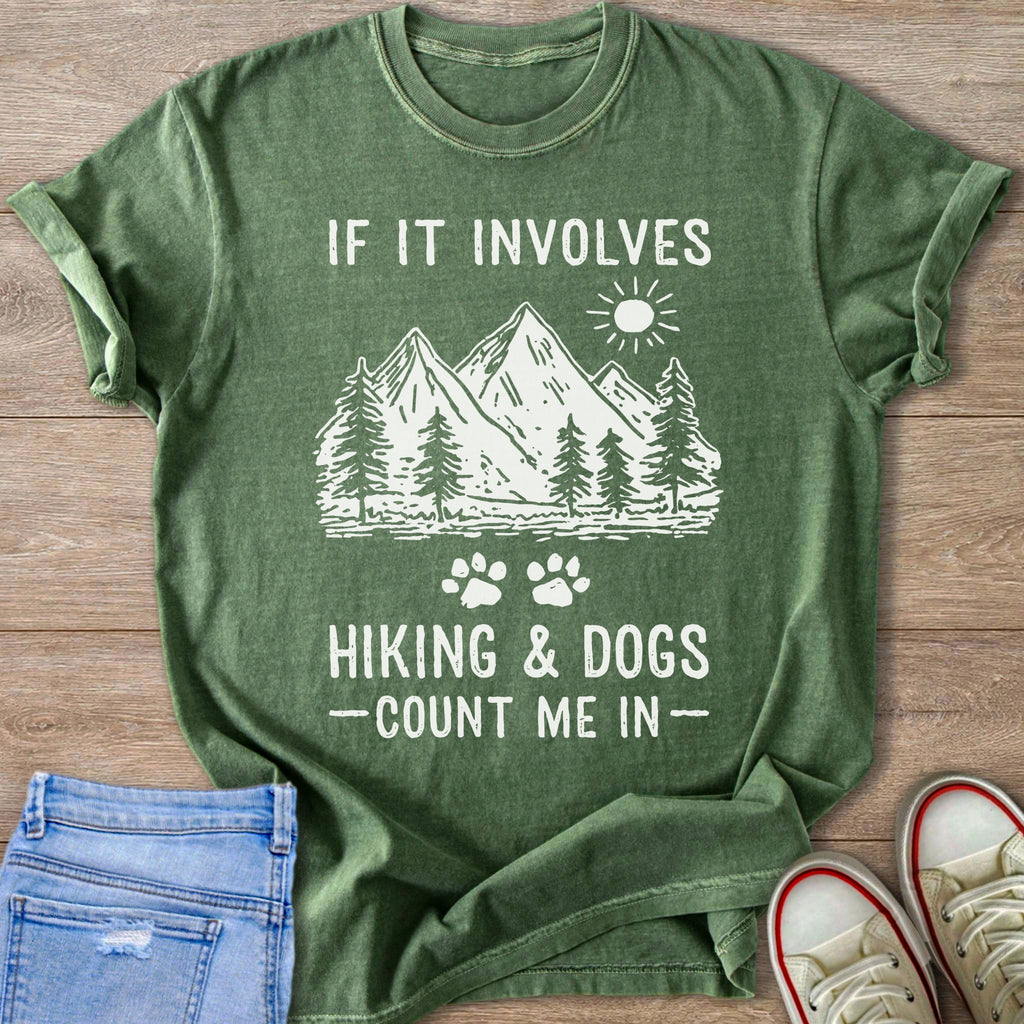 Green t-shirt with white text: "IF IT INVOLVES HIKING & DOGS -COUNT ME IN-" and a mountain landscape.