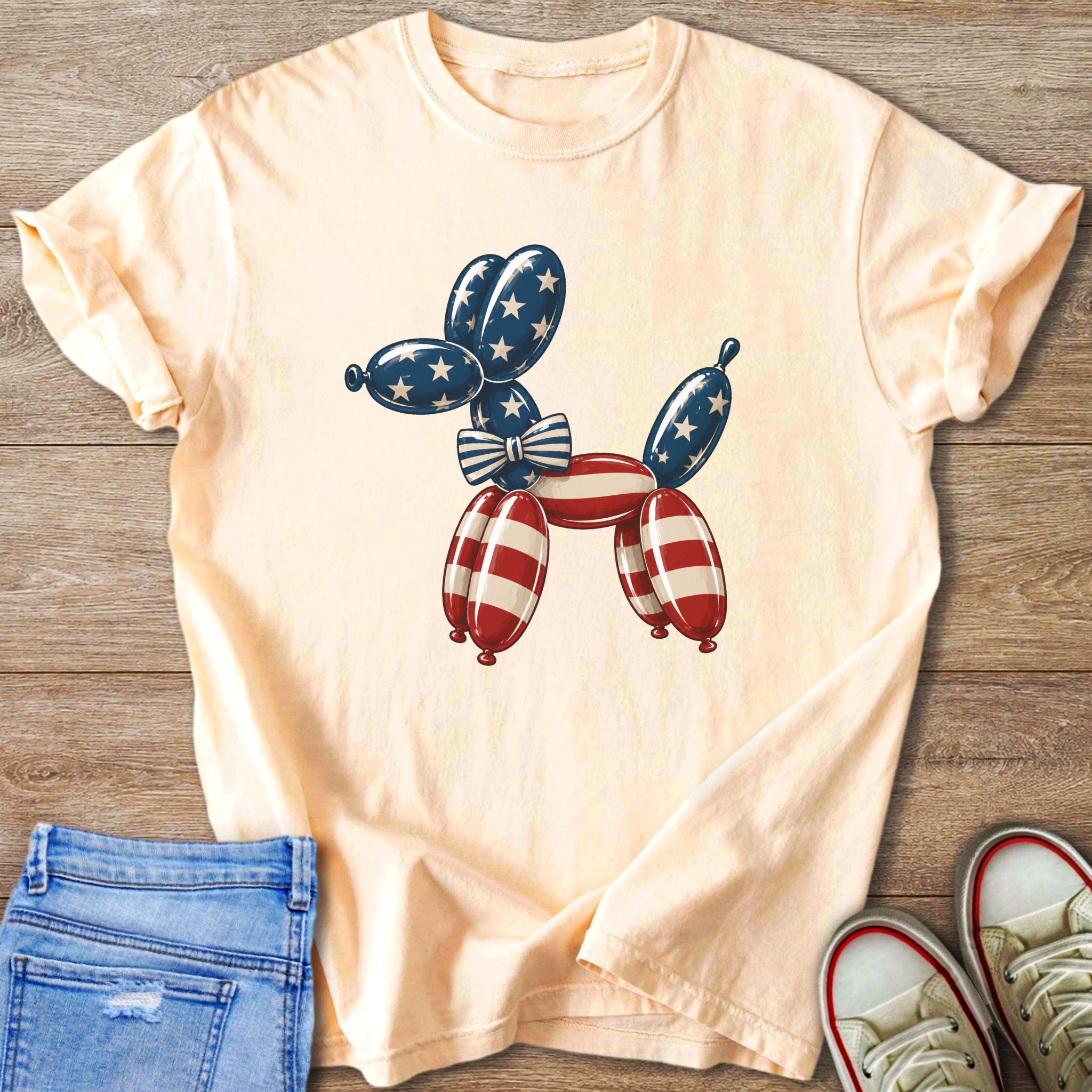 Peach t-shirt with a balloon dog graphic in red, white, and blue.