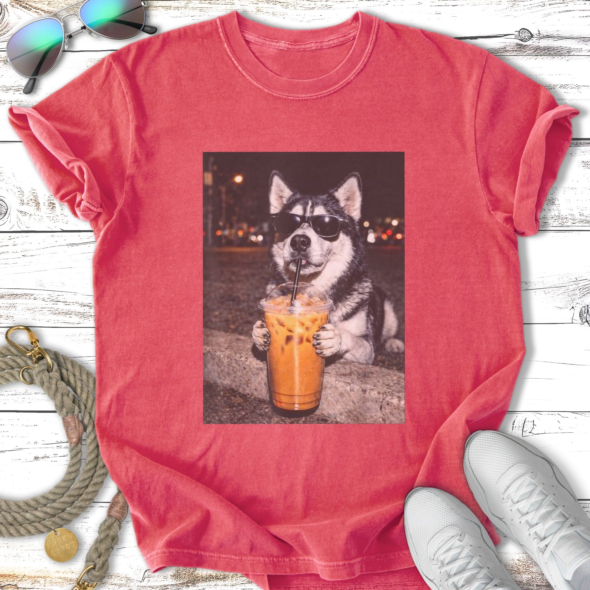Husky wearing sunglasses drinks iced coffee with straw.