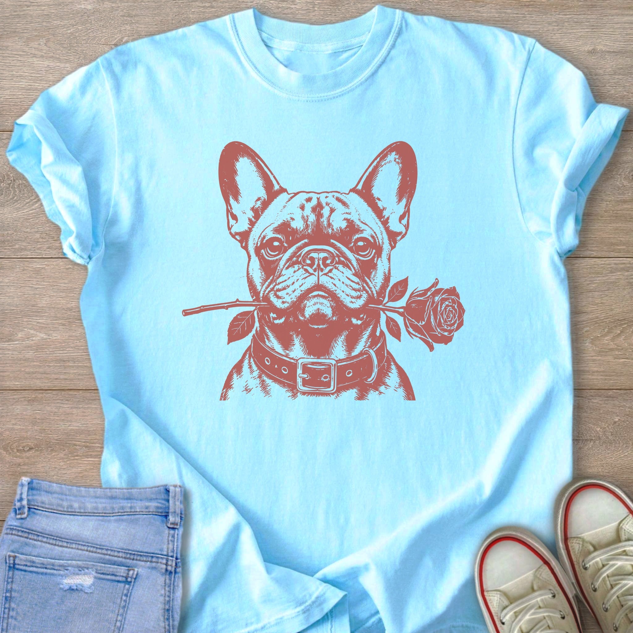 Light blue t-shirt with a brown French Bulldog graphic holding a rose in its mouth.